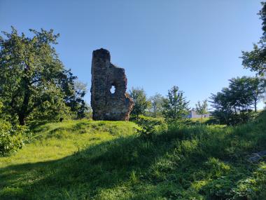 Další rozpadlá zeď, kolem je travnatý plácek a pevnostní valy, nyní porostlé stromy