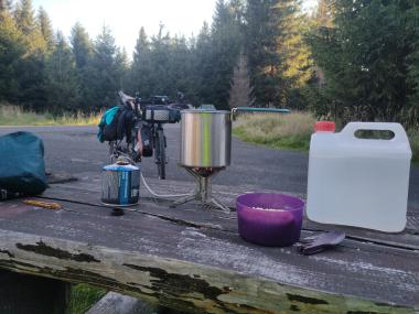 Kempingový vařič na stole na odpočívadle u lesní cesty